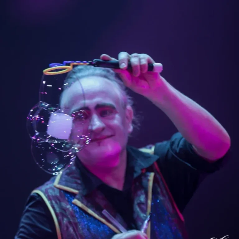 Stephan Masur Barock Seifenblasenshow Ein Zirkuskünstler erschafft mit Freude Seifenblasen unter buntem Licht.